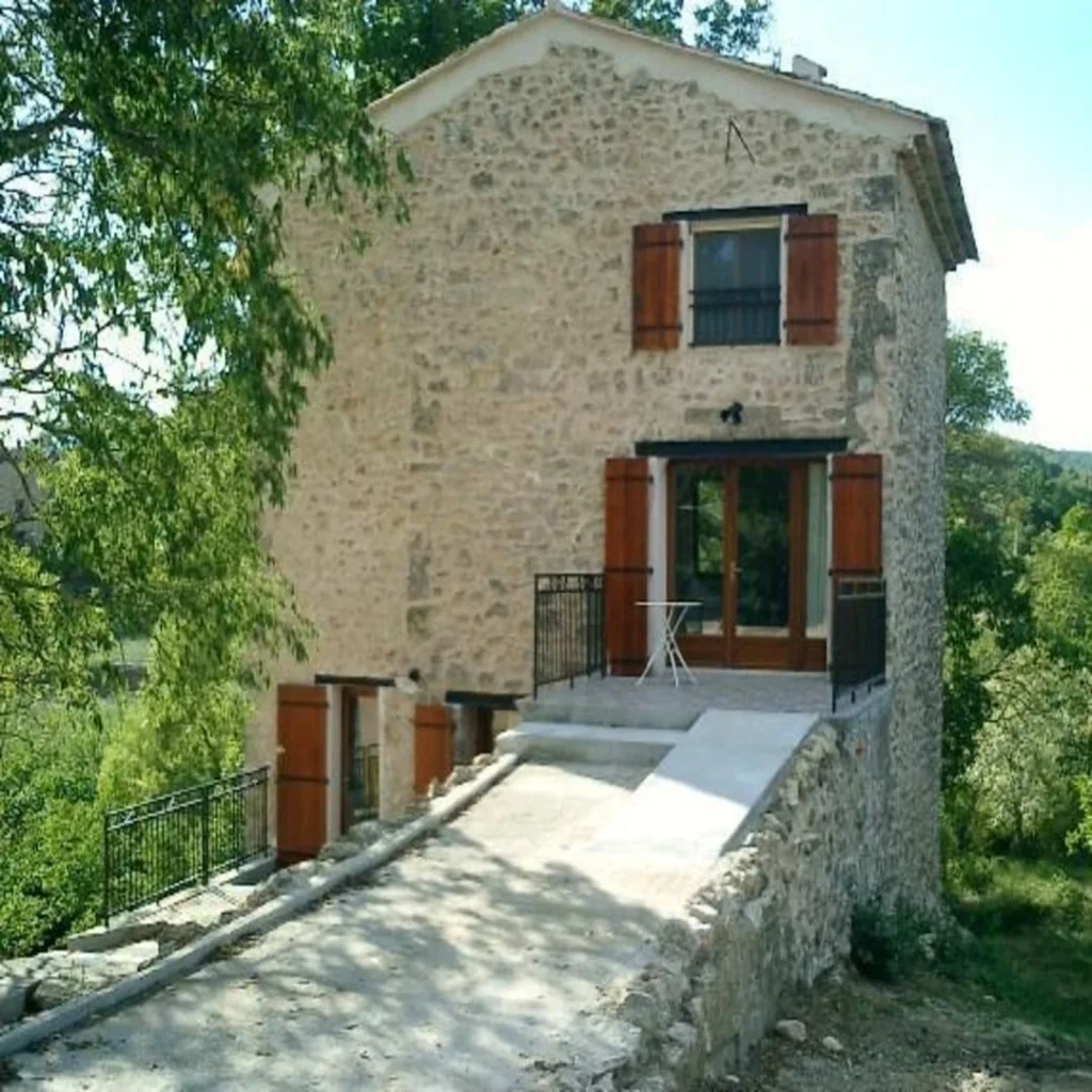 Batisse en pierre avec volets rouge