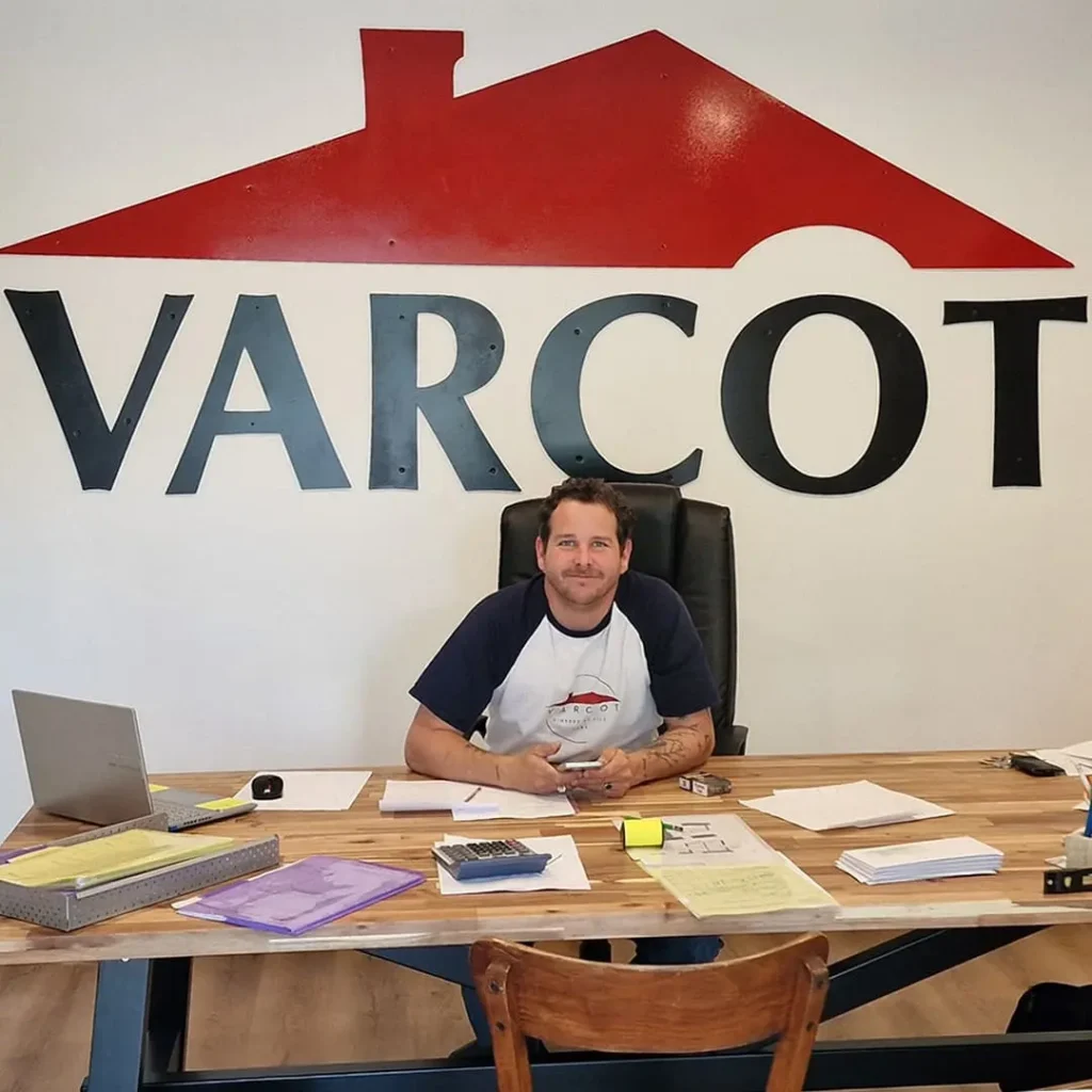 Patron de Varcot assis à son bureau